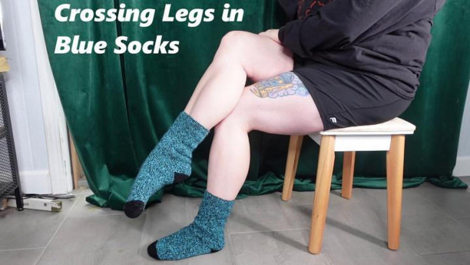 Crossing Muscular Legs In Blue And Black Socks