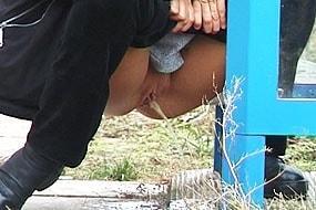 Woman Peeing in Phone Booth