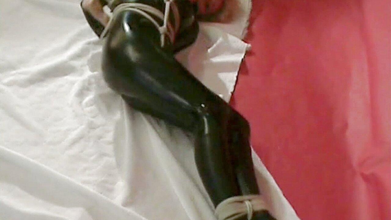 Blonde with Big Boobs in a Latex Jumpsuit Is Severely Hogtied in Bdsm Scene
